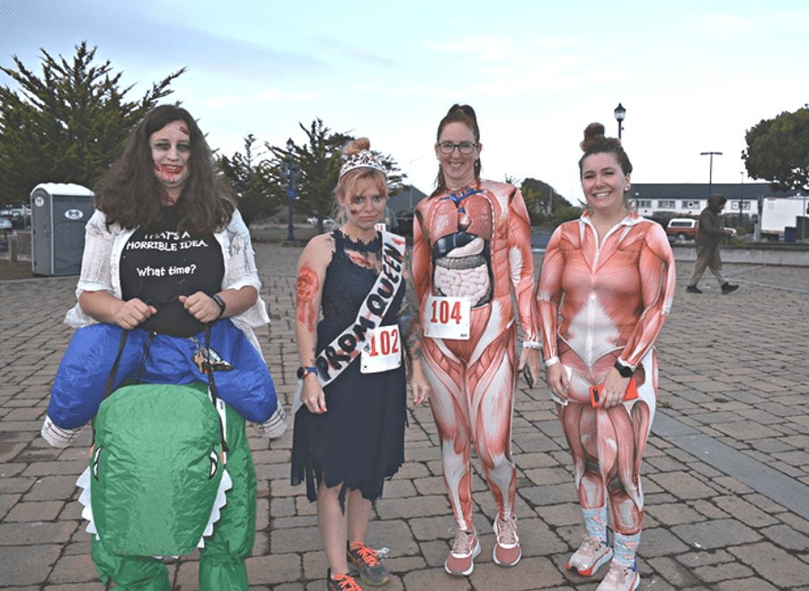 People in Halloween costumes, most notably human body costumes, at the 2022 zombie run-themed Nation's Finest Anniversary 5k in Eureka, CA
