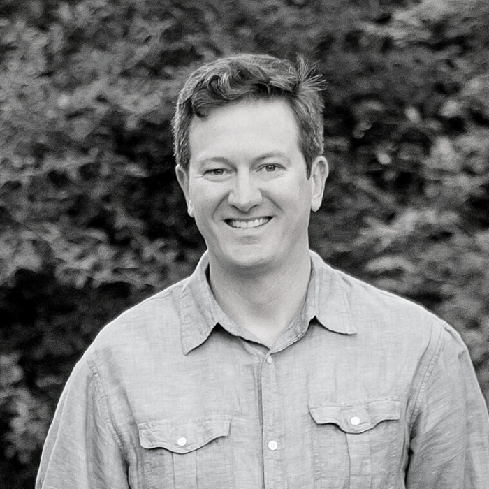 Photo of Edward Ayers smiling, styled in black and white